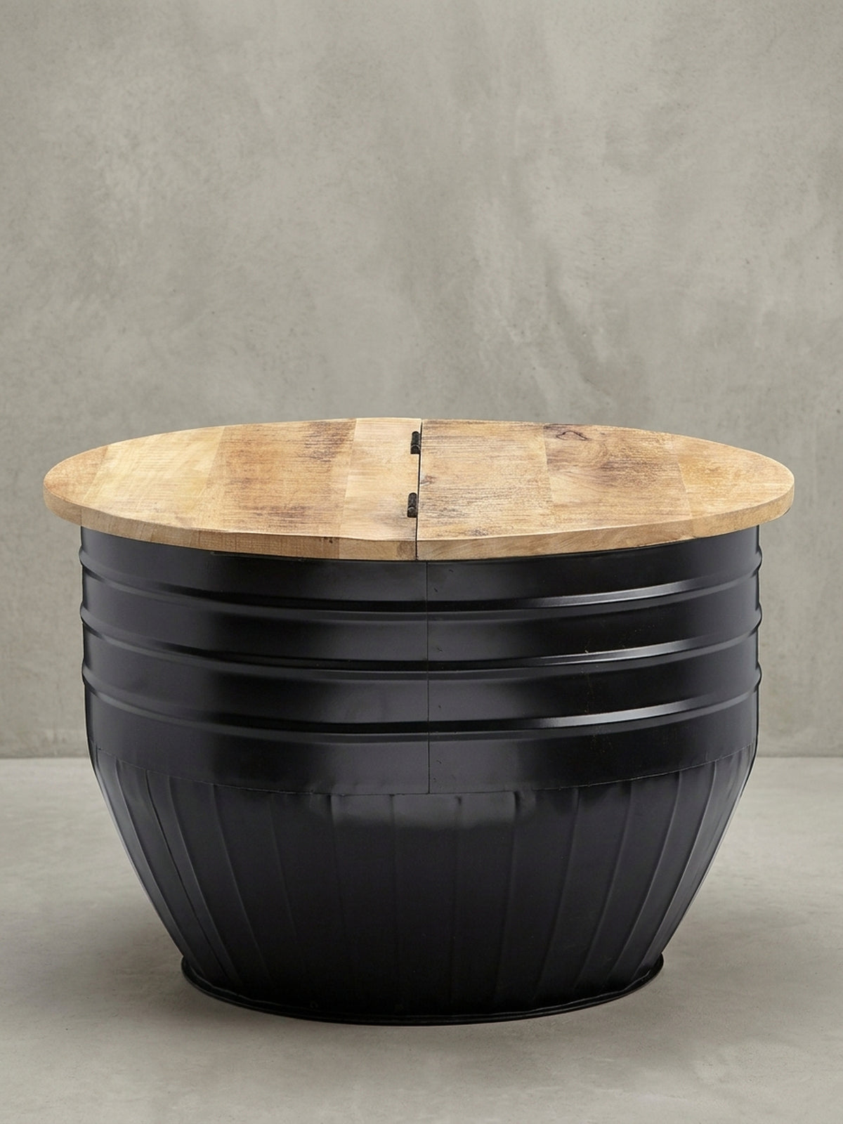 Überblick des runden Industrial Couchtischs (60x41 cm) aus massivem Mangoholz und schwarzem Eisen, ein funktionales Designmöbel mit verstecktem Stauraum._