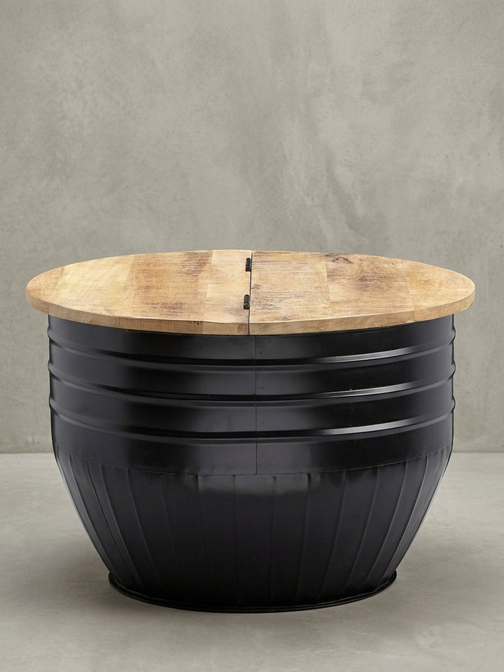 Überblick des runden Industrial Couchtischs (60x41 cm) aus massivem Mangoholz und schwarzem Eisen, ein funktionales Designmöbel mit verstecktem Stauraum._