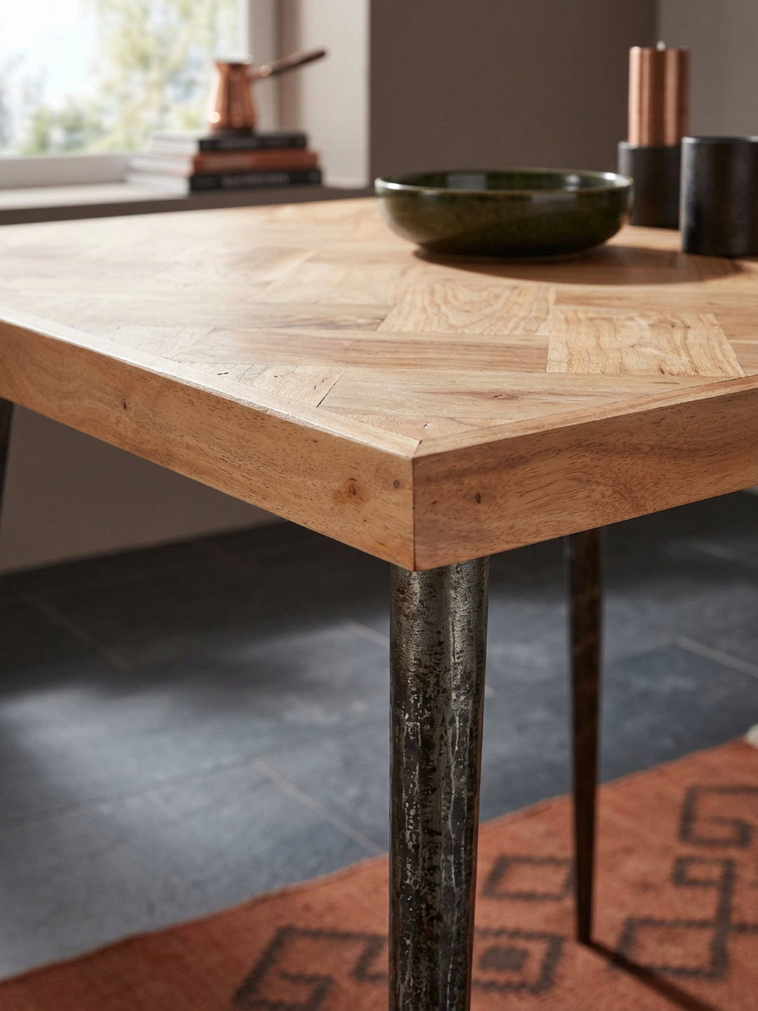 Detailaufnahme der Tischoberfläche des Holztisches: Hochwertiges Akazienholz in aufwendigem Fischgrätmuster trifft auf eine warme, natürliche Maserung im Premium-Esszimmer._