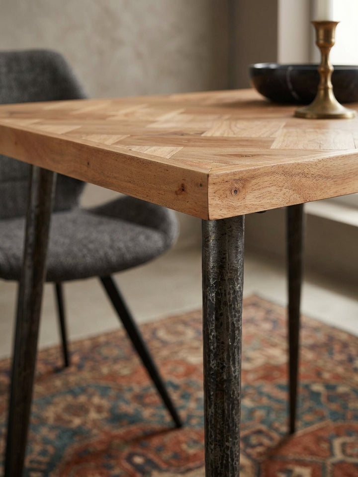 Detailaufnahme der Tischoberfläche des Holztisches: Hochwertiges Akazienholz in aufwendigem Fischgrätmuster trifft auf eine warme, natürliche Maserung im Premium-Esszimmer._