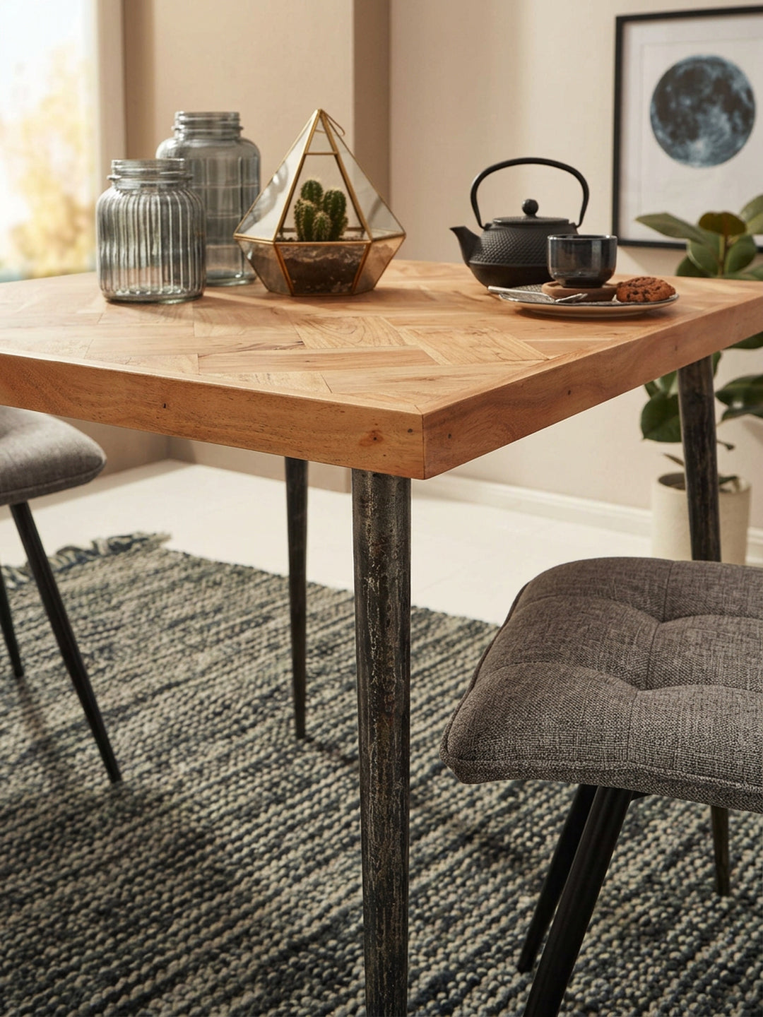 Detailaufnahme der Tischoberfläche des Holztisches: Hochwertiges Akazienholz in aufwendigem Fischgrätmuster trifft auf eine warme, natürliche Maserung im Premium-Esszimmer._