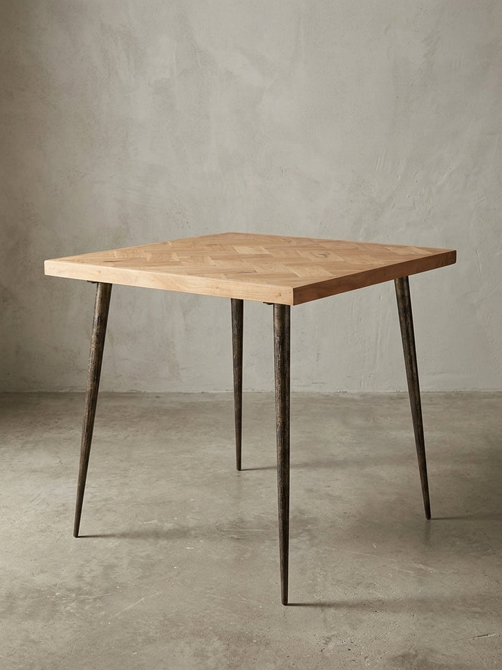 Gesamtübersicht des kleinen Esszimmertisches im Industrial-Stil. Die Kombination aus 80x80 cm massivem Akazienholz und dunklem Metall bietet kompaktes, langlebiges Design für kleine Räume._