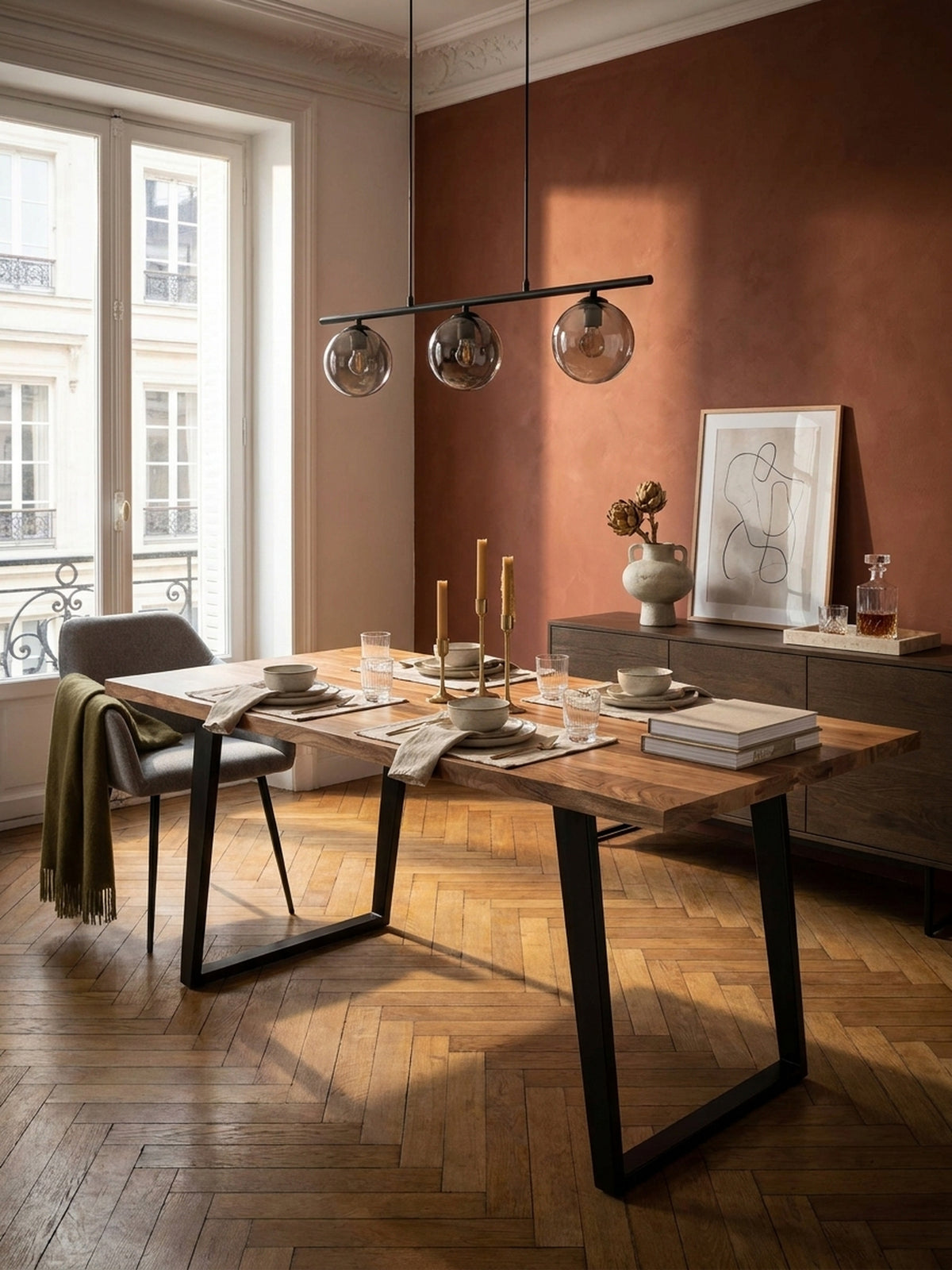 Esstisch aus Akazie Massivholz mit schwarzen U-Beinen im Mittelpunkt eines eleganten Esszimmers mit Fischgrätparkett und großen Fenstern._
