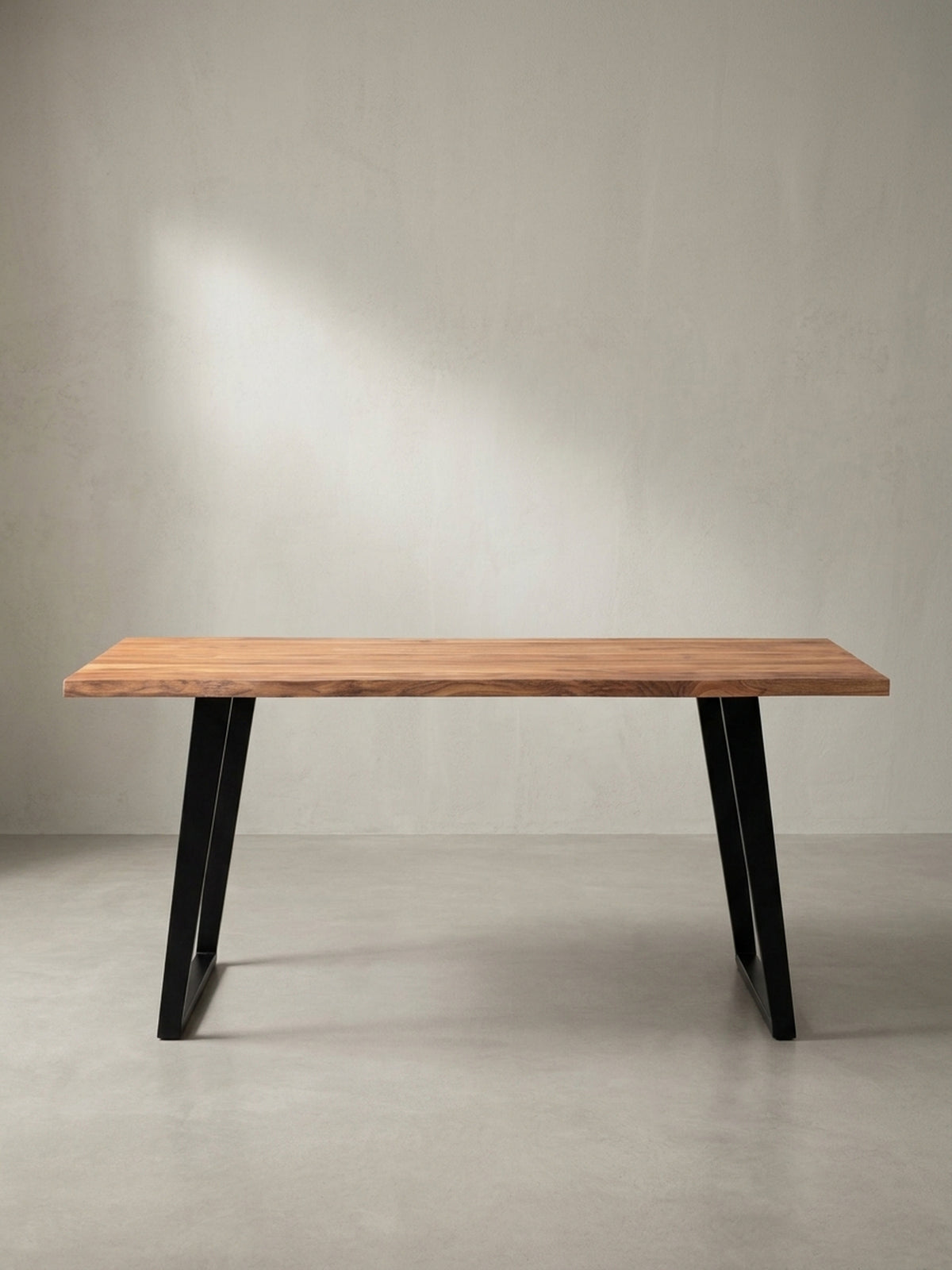 Design-Esstisch aus Akazienholz mit Baumkante in schräger 3/4-Ansicht, die die Tiefe der massiven Tischplatte und die stabilen Metallbeine zeigt._