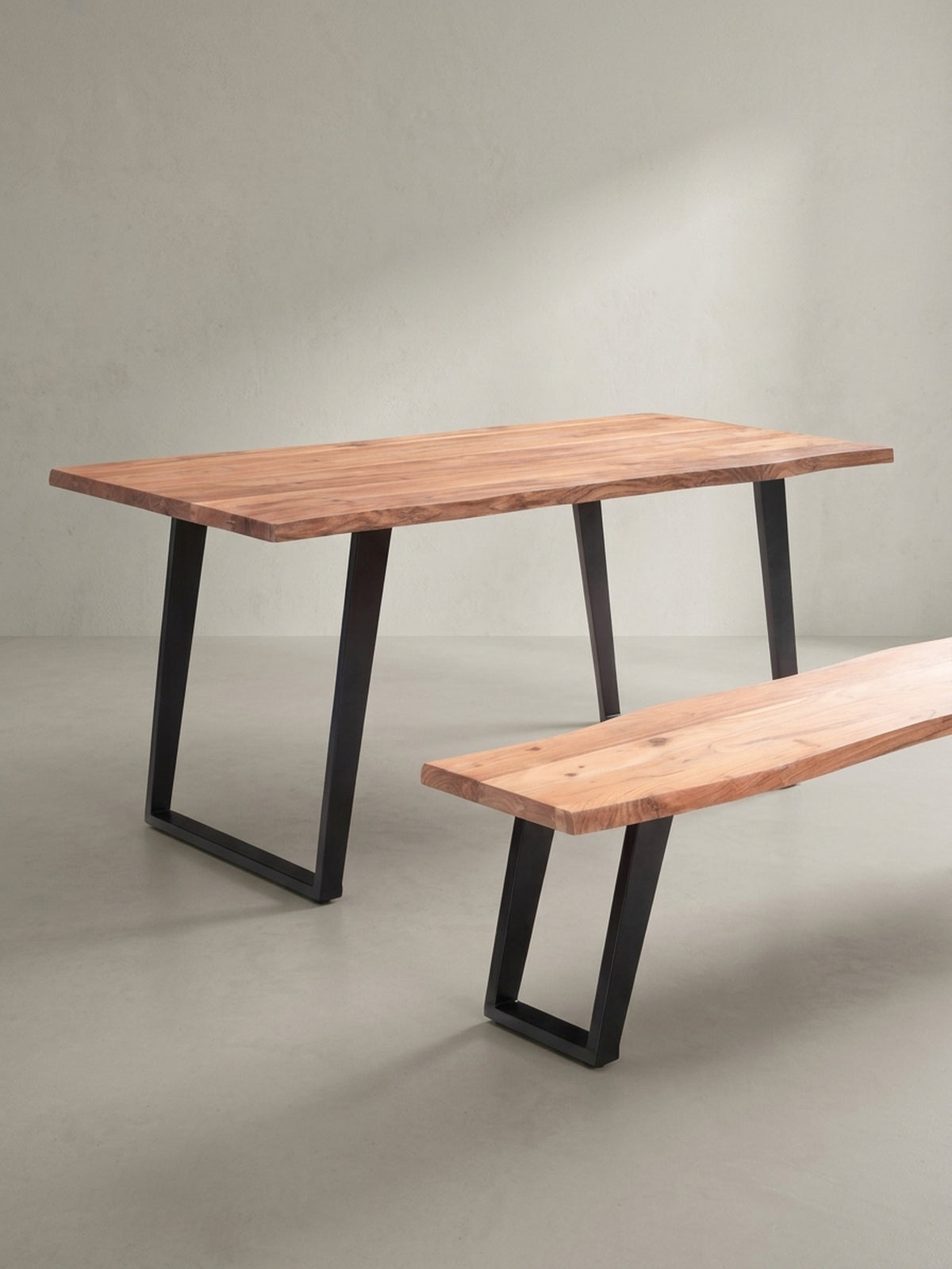 Design-Esstisch aus massivem Holz und Metall in einer schrägen 3/4-Ansicht, die die Tiefe der 4 cm starken Tischplatte und die stabile Konstruktion der Beine zeigt._