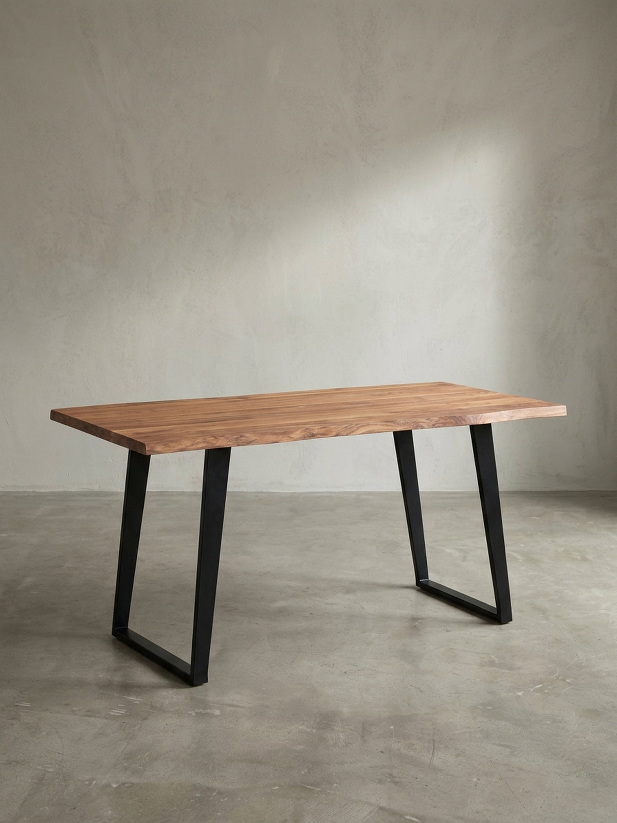 Schräger Blick auf den Esszimmertisch aus Akazie, der die Tiefe der 4 cm dicken Massivholzplatte und das minimalistische Design des Metallgestells zeigt._