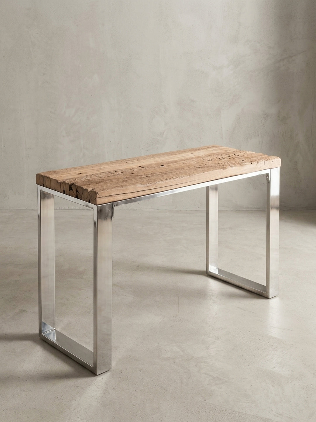 Alternative Perspektive des Industrial Konsolentisches. Das minimalistische Design lenkt den Fokus auf die organische Form der Holzkante und den Glanz des rostfreien Stahls._