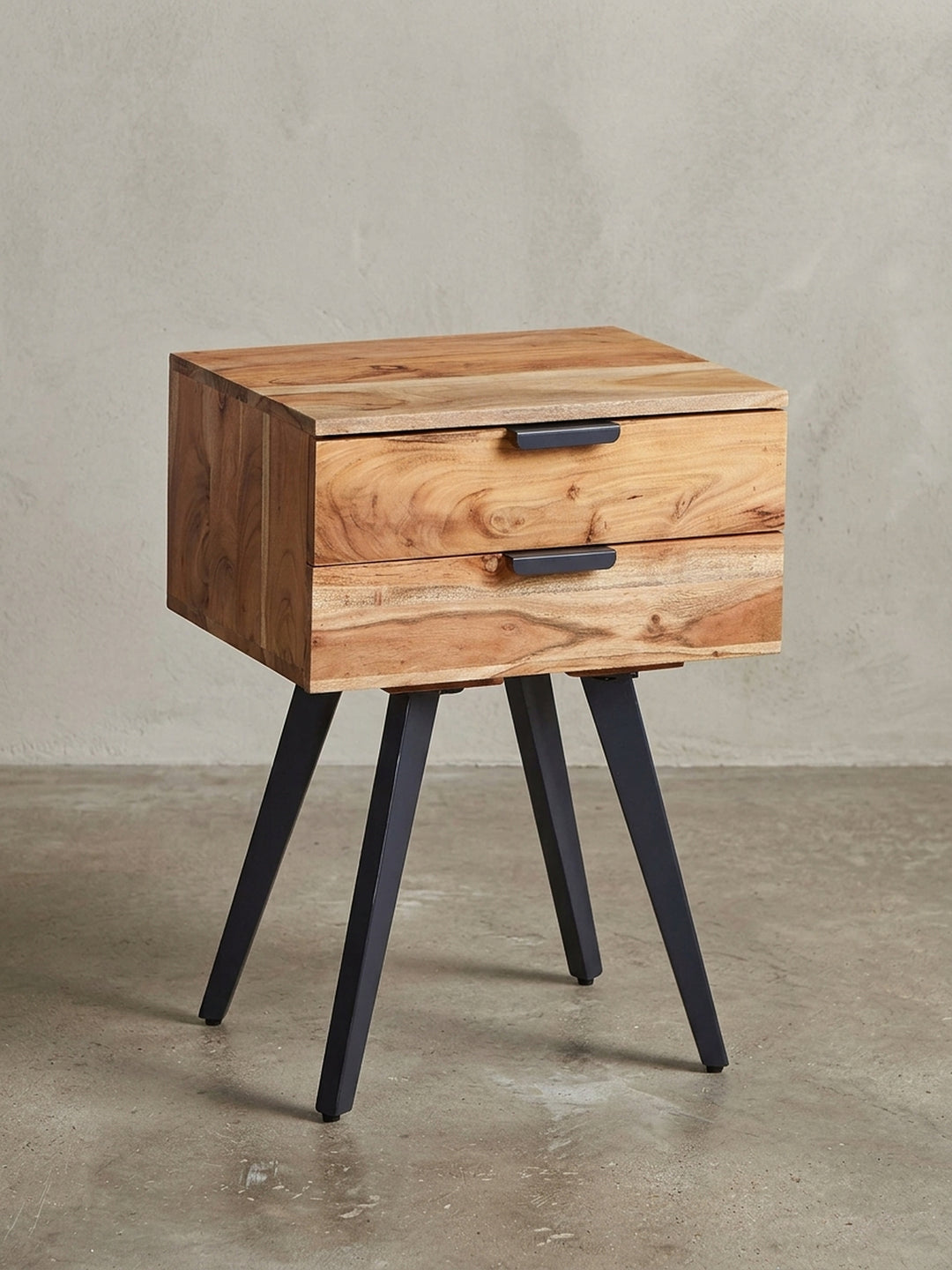 Freigestellte Frontansicht der Nachtkonsole aus Akazie Massivholz, die ihre zwei Schubladen und die schlanken schwarzen Metallbeine zeigt._