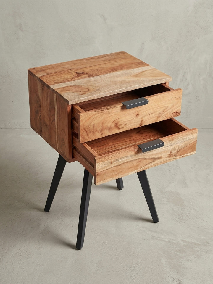 Perspektivische Ansicht des Akazien-Nachtkästchens, die das harmonische Zusammenspiel der warmen Holzoberfläche und der kühlen Metallgriffe betont._