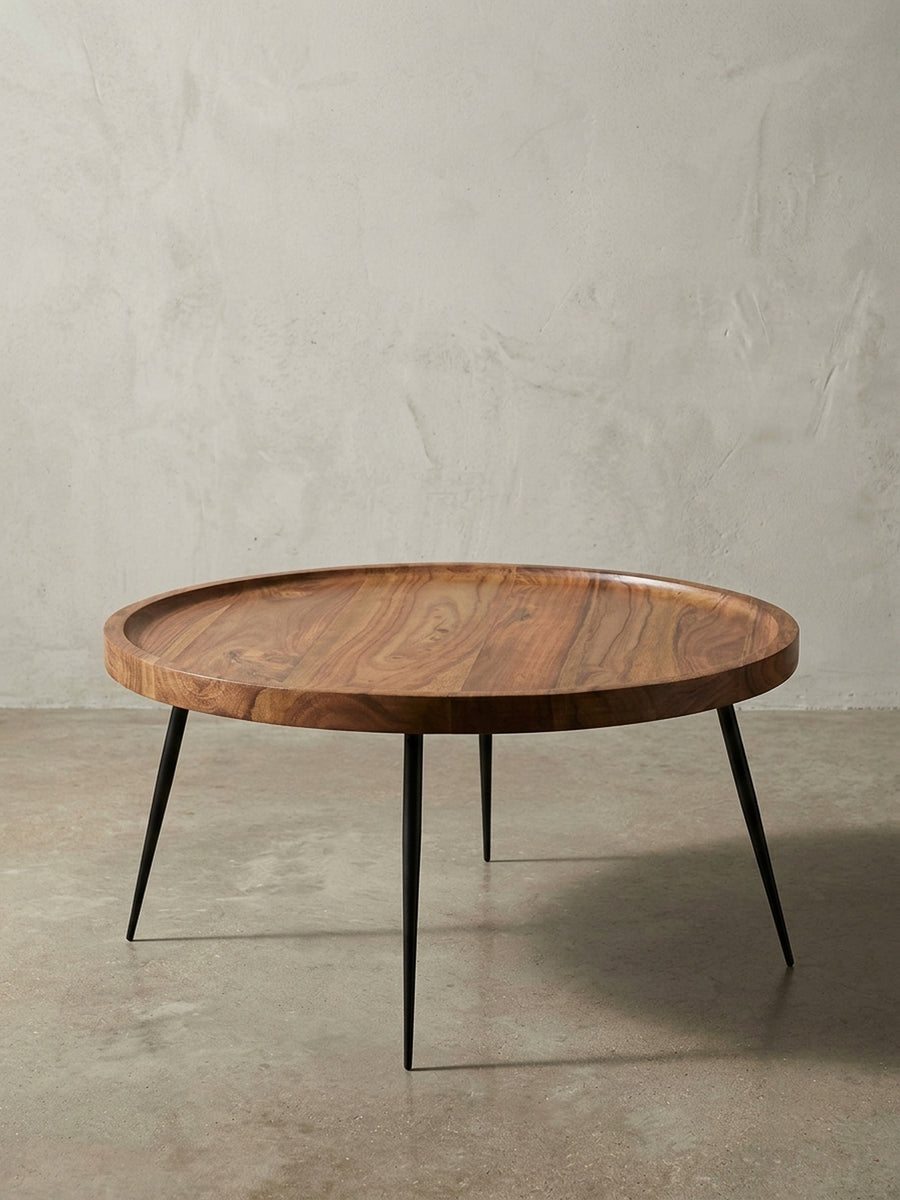 Detailansicht der Tischunterseite und Beinkonstruktion. Die robuste Verschraubung der schwarzen Eisenbeine an der massiven Sheesham-Holzplatte sorgt für Stabilität beim Sofatisch._