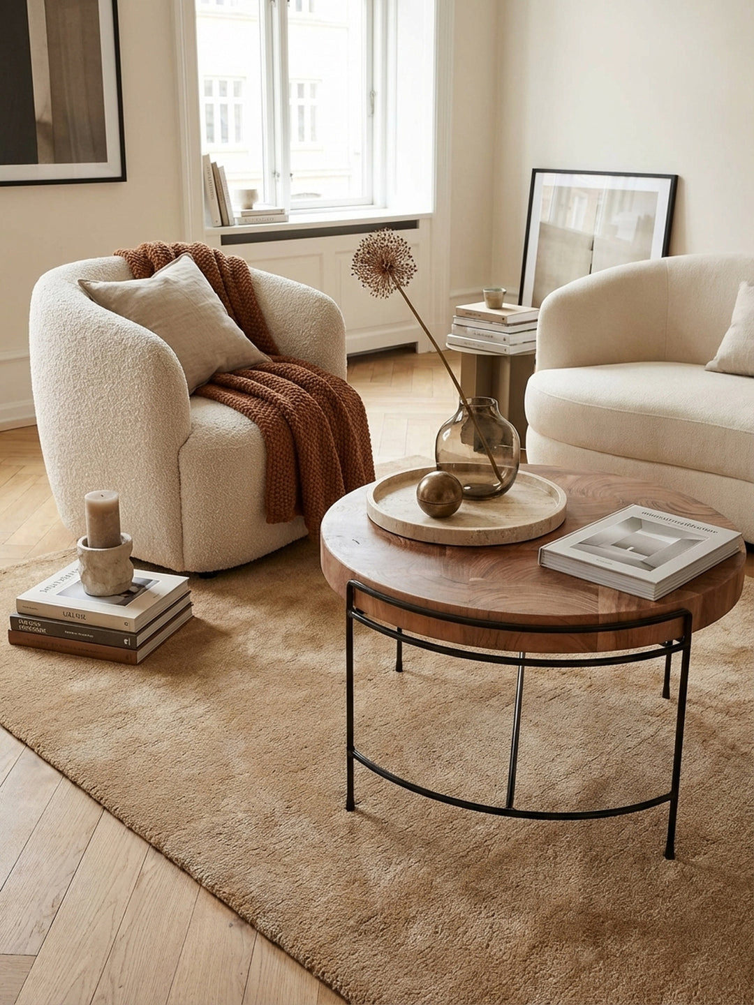 Eleganter runder Couchtisch aus massivem Akazienholz in einem hellen, luxuriösen Wohnzimmer, kombiniert mit einem beigen Sofa und einem weichen Wollteppich._