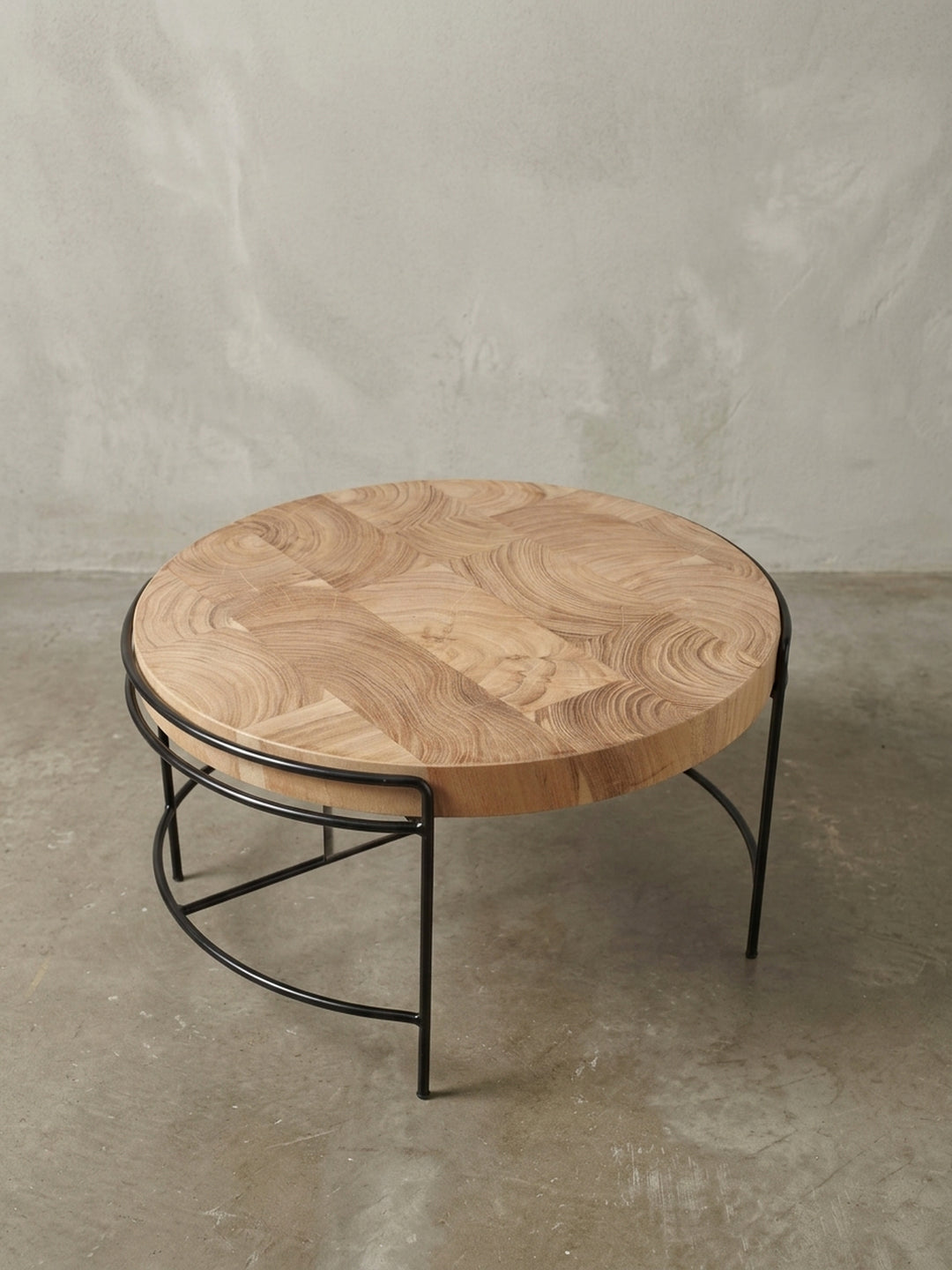 Alternative Perspektive auf den Massivholz-Couchtisch, die das Zusammenspiel der warmen Holztöne und des kühlen schwarzen Metalls hervorhebt._