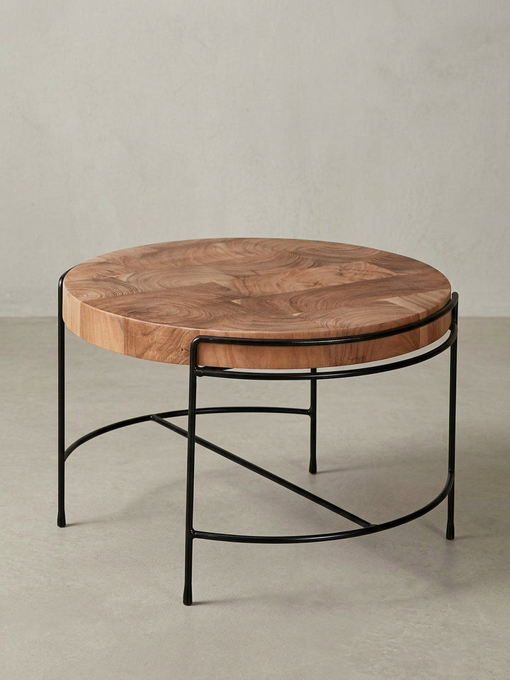 Designer Holztisch in 3/4-Ansicht, die massive 5,5 cm dicke Tischplatte aus Akazie und die eleganten Metallbeine des Wohnzimmertisches sind gut erkennbar._