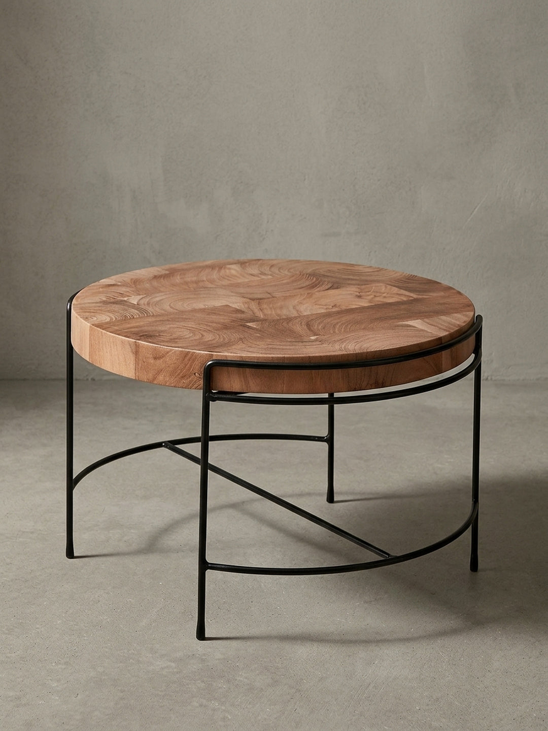 Runder Couchtisch mit Tischplatte aus Akazie Massivholz und filigranem schwarzen Metallgestell, freigestellt auf weißem Hintergrund, Frontansicht._
