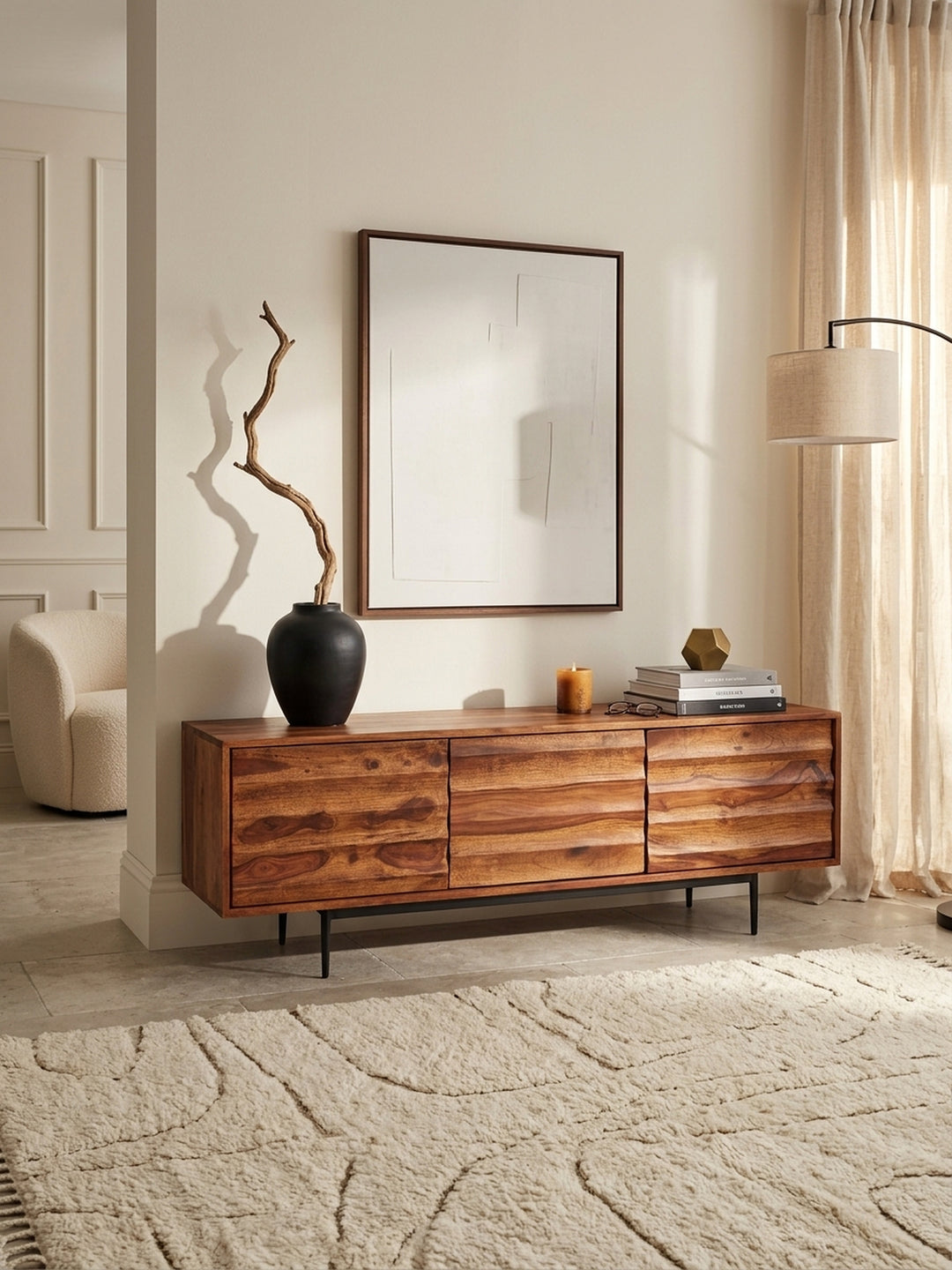 Draufsicht auf das Wohnzimmer-Setup mit dem massiven Sheesham Holz Fernsehschrank. Die 38cm tiefe Ablagefläche bietet perfekten Raum für stilvolle Dekoration und HiFi-Geräte._
