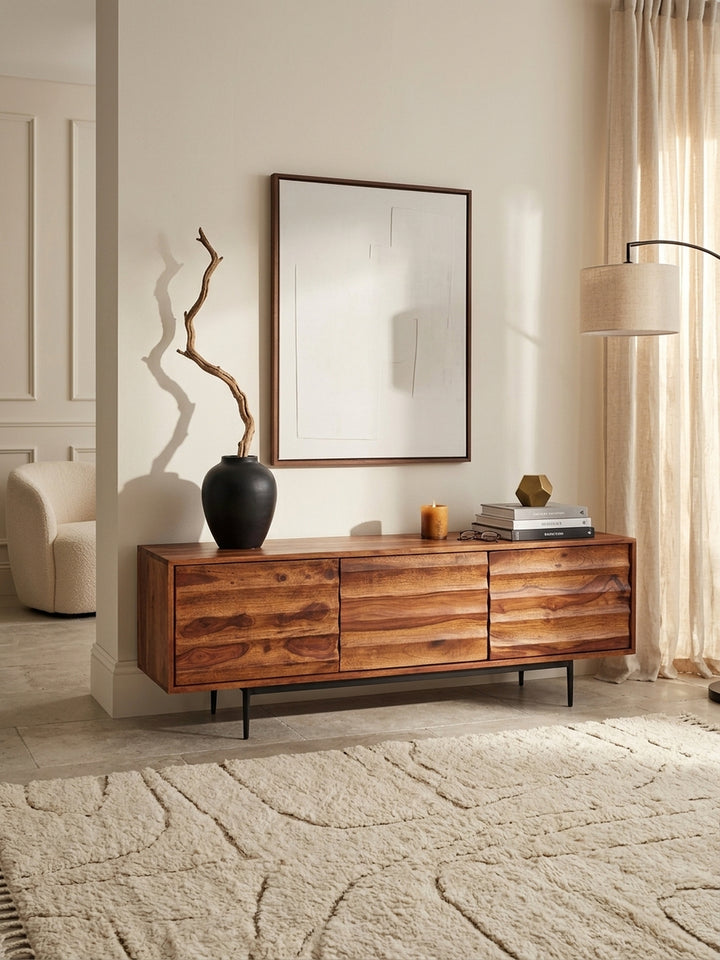 Draufsicht auf das Wohnzimmer-Setup mit dem massiven Sheesham Holz Fernsehschrank. Die 38cm tiefe Ablagefläche bietet perfekten Raum für stilvolle Dekoration und HiFi-Geräte._