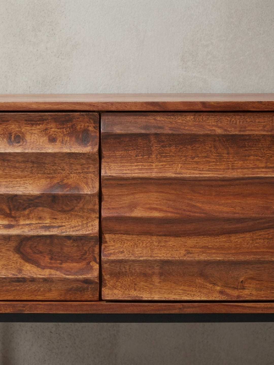 Detailansicht der grifflosen Fronten und der präzisen Fräsung am Sheesham Holzschrank. Die ausdrucksstarke Maserung macht jede Fernsehkommode zu einem absoluten Einzelstück._