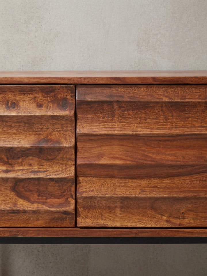 Detailansicht der grifflosen Fronten und der präzisen Fräsung am Sheesham Holzschrank. Die ausdrucksstarke Maserung macht jede Fernsehkommode zu einem absoluten Einzelstück._