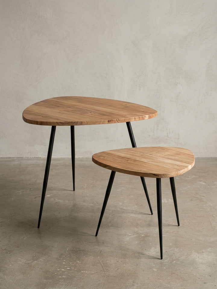 Design Beistelltisch Set in Nierenform aus einer schrägen 3/4-Perspektive, die schlanken, gespreizten Metallbeine und die massive Holzplatte aus Akazie sind deutlich zu sehen._