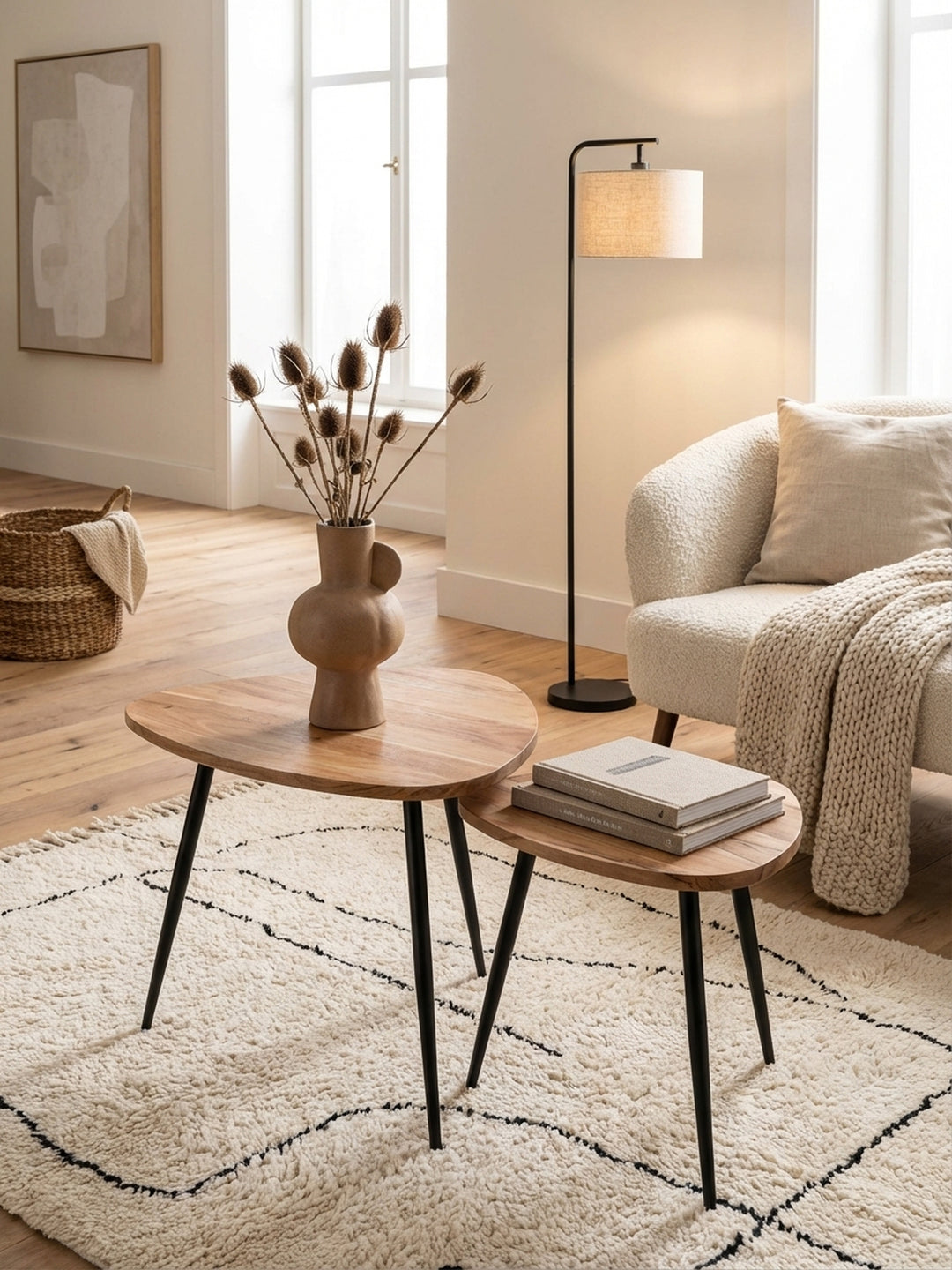 Zwei Satztische aus Akazie Massivholz in einem stilvollen Wohnzimmer, die organische Form der Holztische harmoniert mit dem weichen Teppich und dem modernen Sofa im Hintergrund._