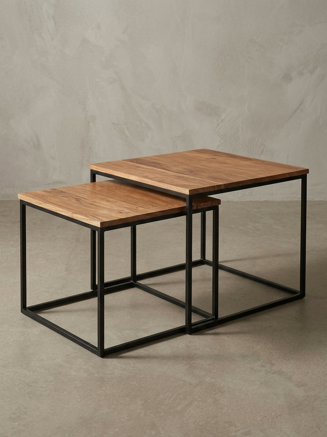 Flexibler Sofatisch als 2er Set, dessen ineinandergeschobene Form und industrielle Ästhetik aus einem seitlichen Blickwinkel gezeigt wird._