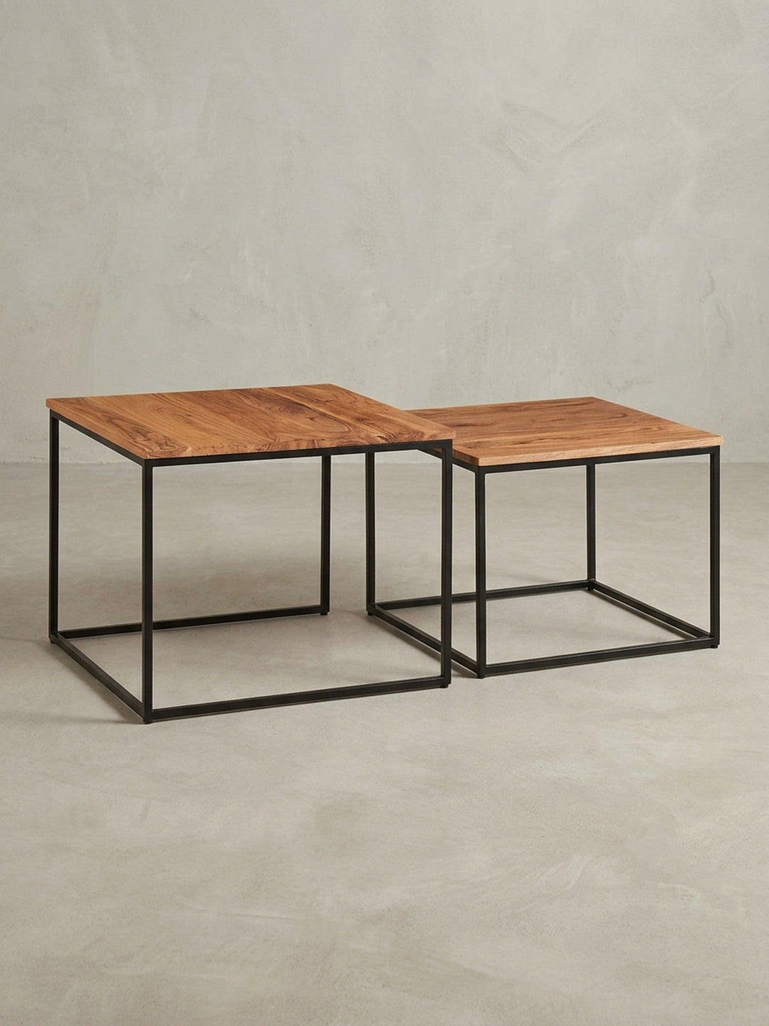 Überblick über das zweiteilige Satztisch-Set, das die harmonische Kombination von warmem Massivholz und kühlem, pulverbeschichtetem Eisen zeigt._