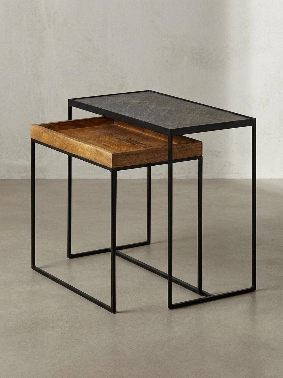 Rechteckiger Beistelltisch in 3/4-Ansicht, der das ineinander schiebbare Design des zweiteiligen Tischsets und die Materialkombination hervorhebt._