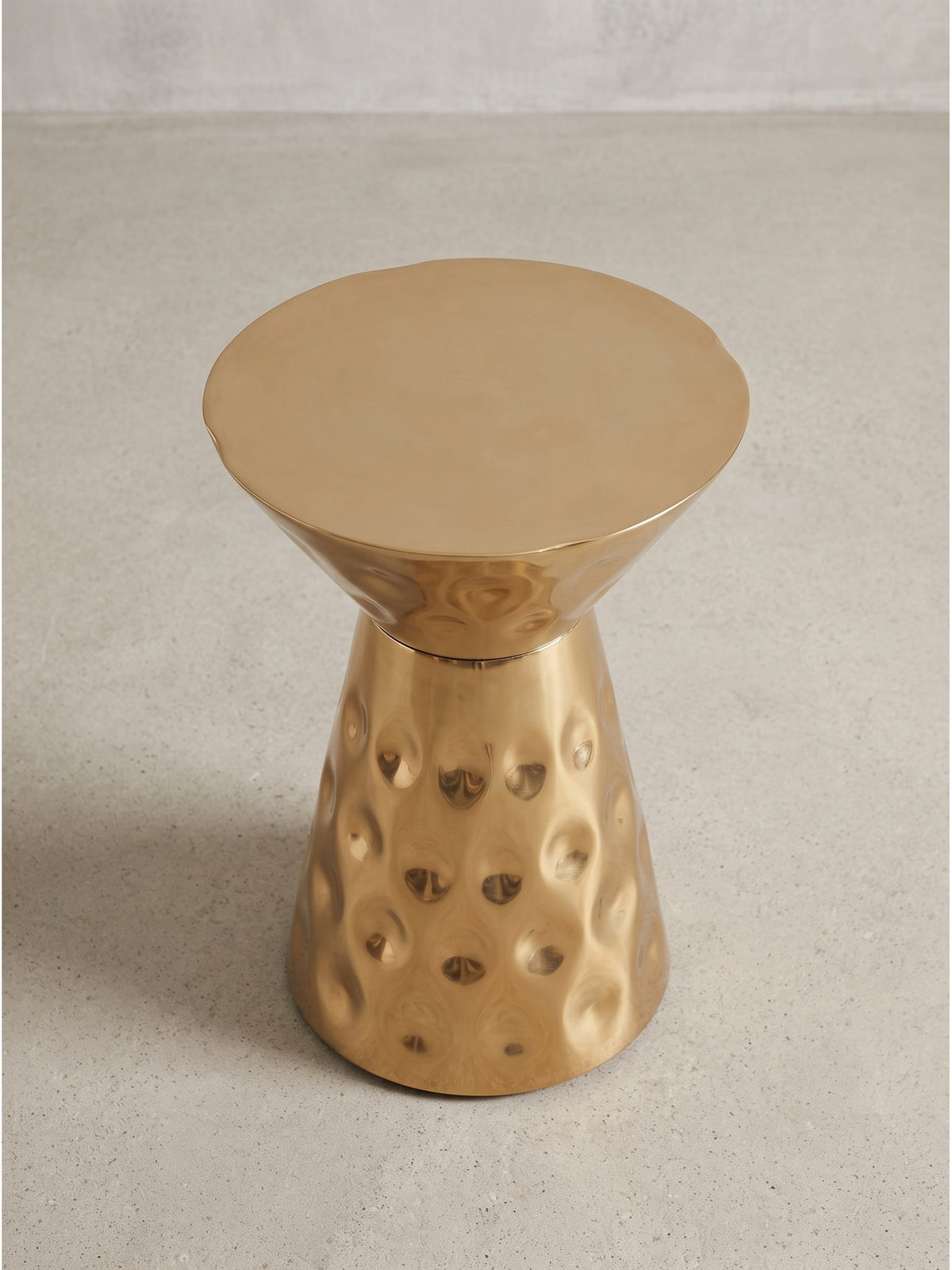 Gehämmerter Anstelltisch aus Aluminium in Gold leicht von der Seite gesehen mit schmaler Mitte und runder Bodenplatte_