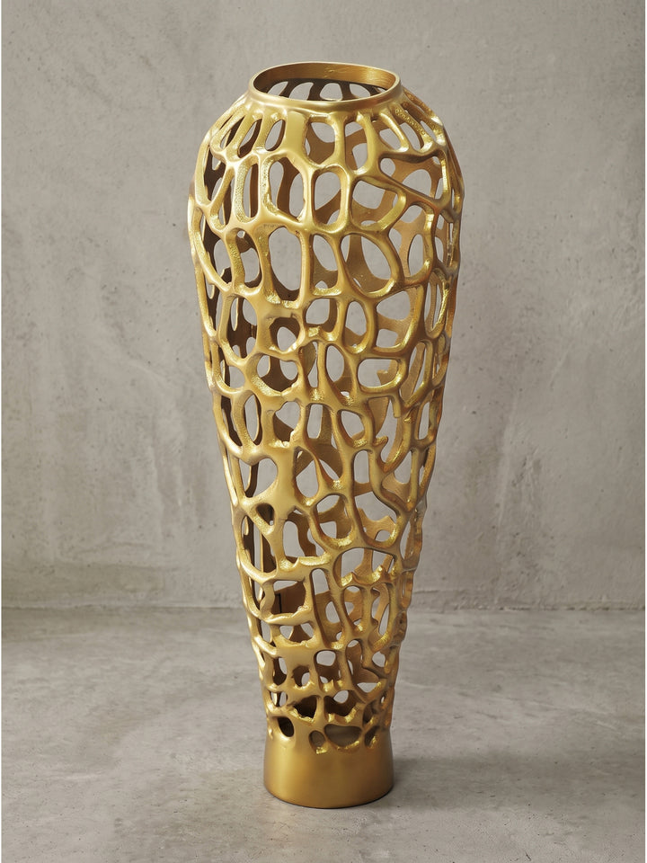 Makroaufnahme der goldenen Beschichtung auf der Aluminiumvase mit Fokus auf die gegossenen Ränder der Durchbrüche_