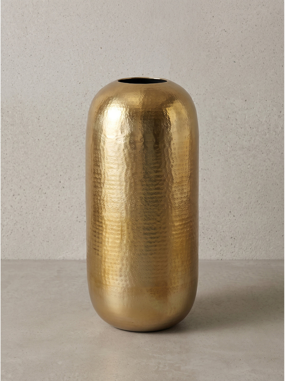 Detailansicht der charakteristischen Unebenheiten der goldenen Vase aus Aluminium als Beweis für die liebevolle traditionelle Handarbeit_