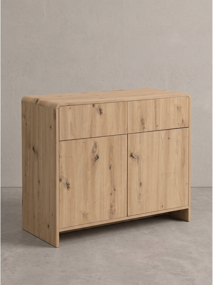 Modernes Sideboard Eiche Dekor 88x40x76 cm in schräger Ansicht links mit abgerundeten Ecken und grifflosem Design_