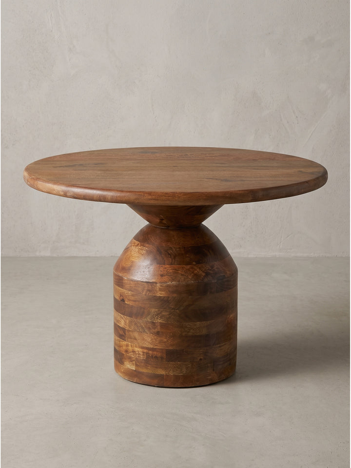 Eleganter Couchtisch aus massivem Mangoholz mit charakteristischem Säulenfuß und 60cm runder Tischplatte in frontaler Ansicht_
