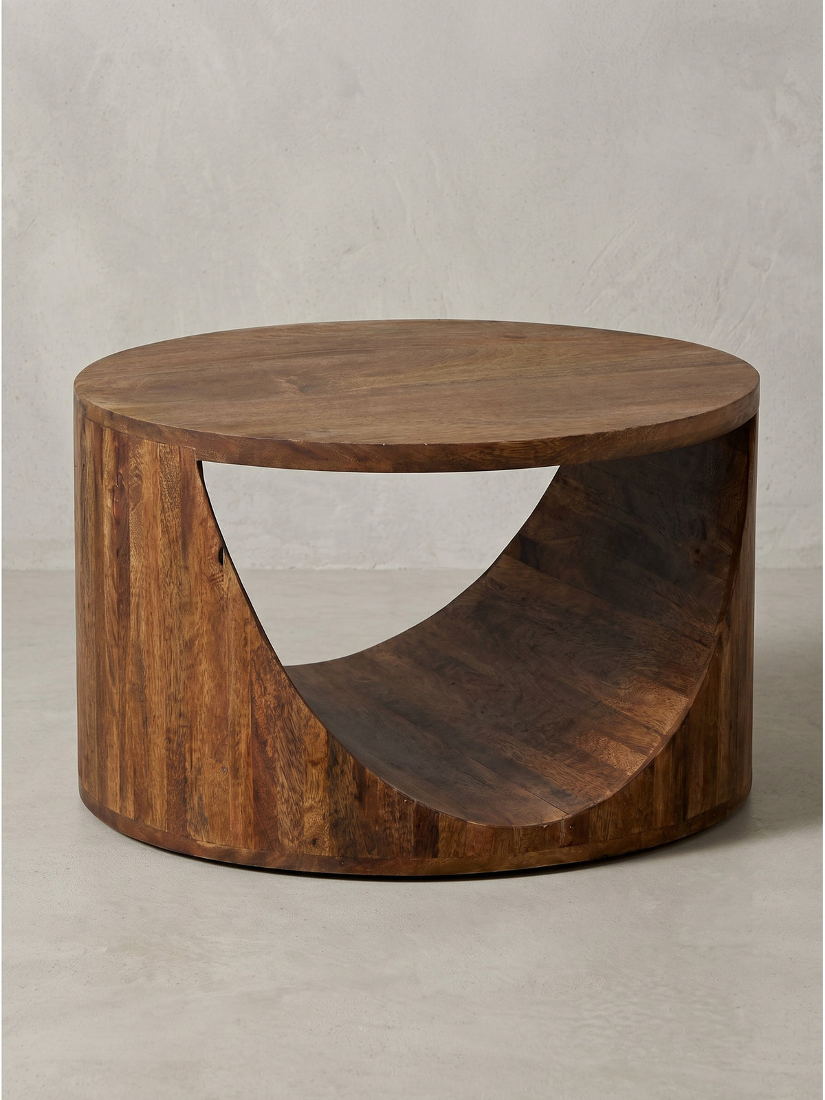Couchtisch Mango Massivholz Rund 60cm mit seitlichem Durchbruch als skulpturales Statement-Piece freigestellt vor weißem Hintergrund