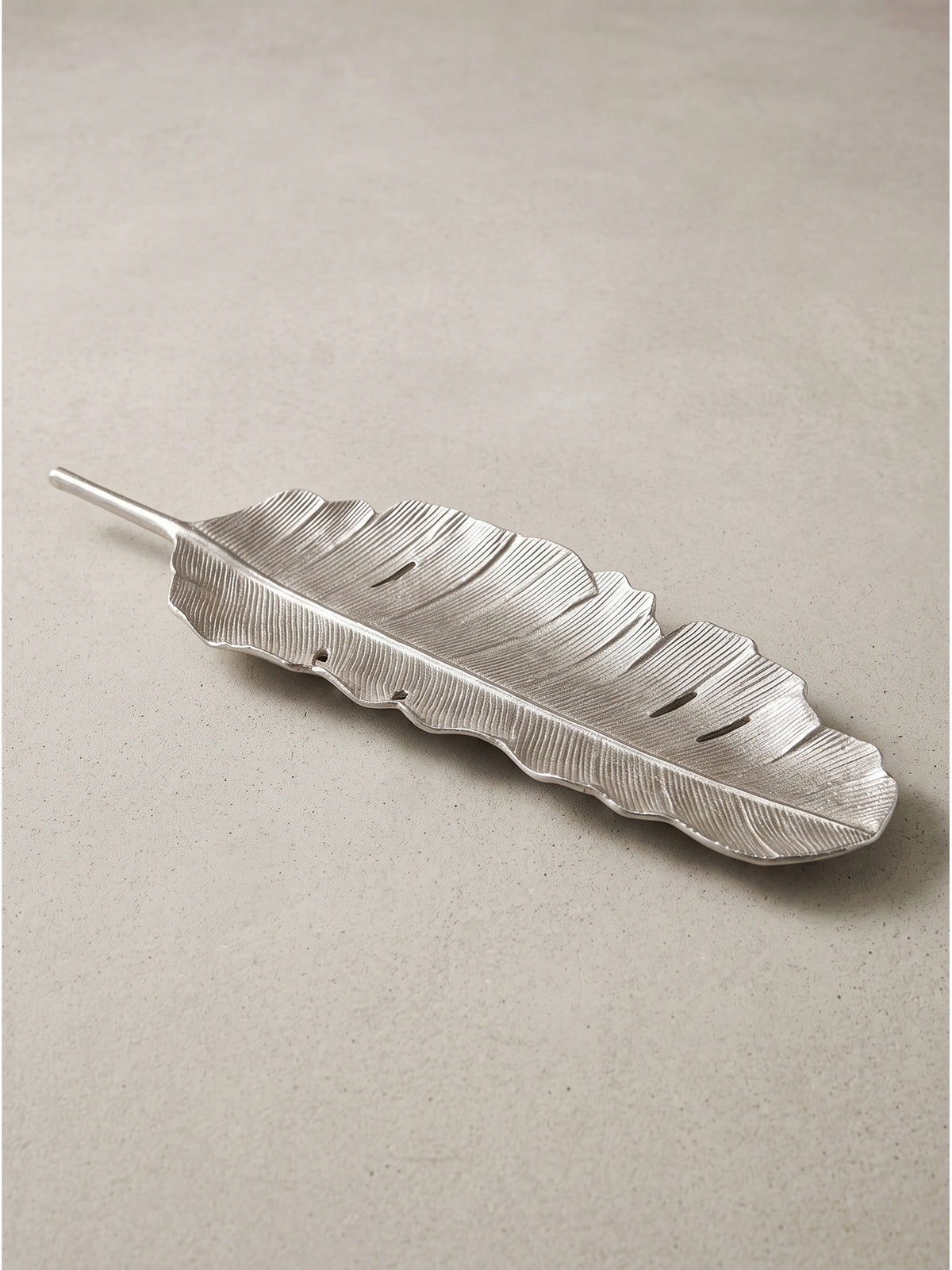Texturdetail der massiven Aluminiumschale in Silber, das die feinen Unebenheiten und filigranen Linien der handwerklichen Verarbeitung hervorhebt._