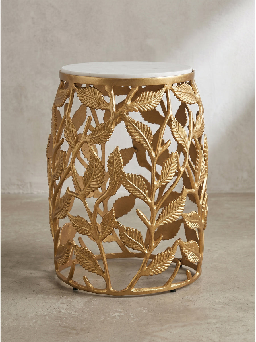 Das Profil dieses luxuriösen Couchtisches offenbart das exakte Zusammenspiel zwischen der stabilen, 29 cm breiten indischen Natursteinplatte und den filigran geformten goldenen Aluminiumzweigen._