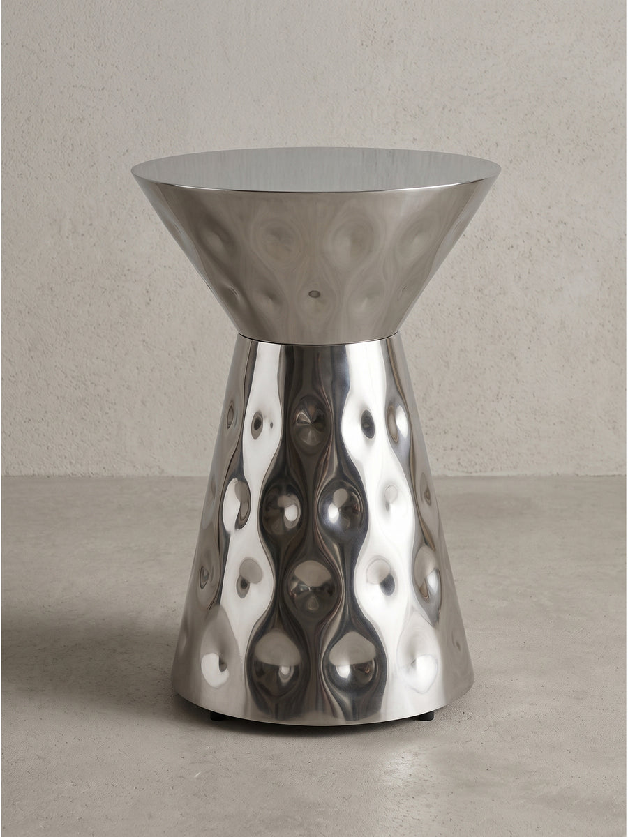 Handgefertigter Beistelltisch aus Aluminium 36x51 cm in Silber mit runder Platte und markant taillierter Form vor weißem Hintergrund._