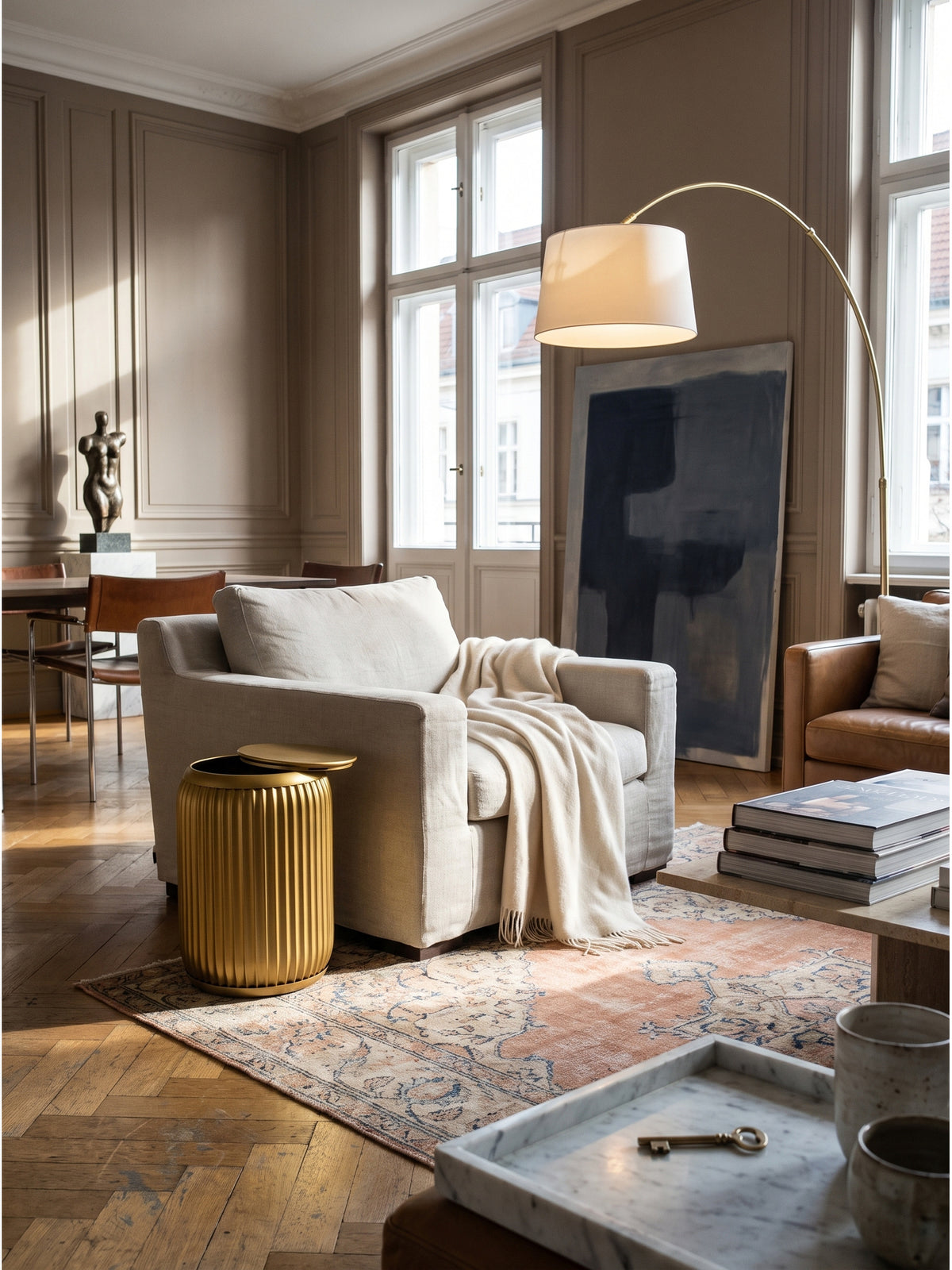 Runder Beistelltisch in Gold 35x50 cm mit Rillenoptik als Highlight im modernen Wohnzimmer neben hellem Leinensofa auf einem Vintage-Teppich_
