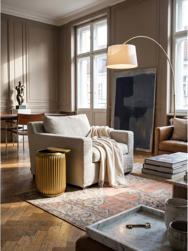 Runder Beistelltisch in Gold 35x50 cm mit Rillenoptik als Highlight im modernen Wohnzimmer neben hellem Leinensofa auf einem Vintage-Teppich_