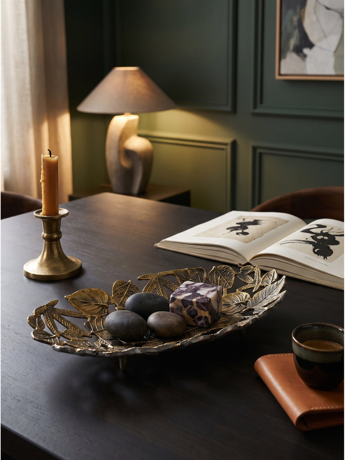 Stimmungsvolles Arrangement mit der 49 cm langen goldenen Schale, bestückt mit cremefarbenen Kerzen und Travertin-Steinen auf einer Anrichte.