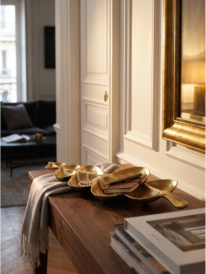 Dekoschale Gold auf einer Konsole mit Perlenkette und Vintage-Parfümflakon arrangiert im klassischen Schlafzimmer_