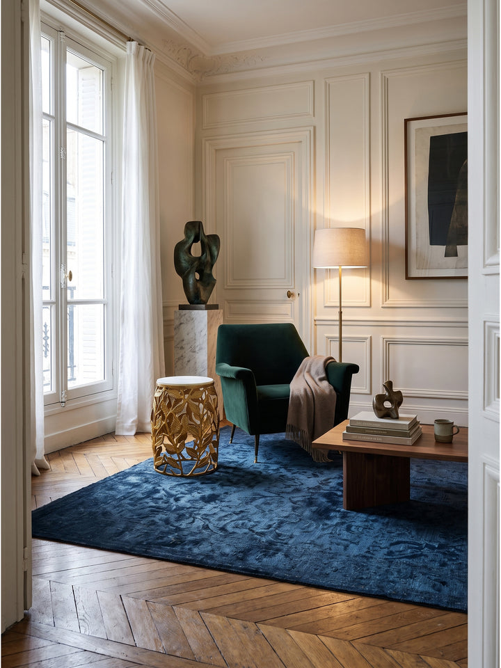 Dieser elegante Beistelltisch mit edler weißer Marmorplatte und goldenem Aluminiumgestell steht als stilvolles Herzstück im luxuriösen Wohnzimmer vor einer klassischen Wandvertäfelung._