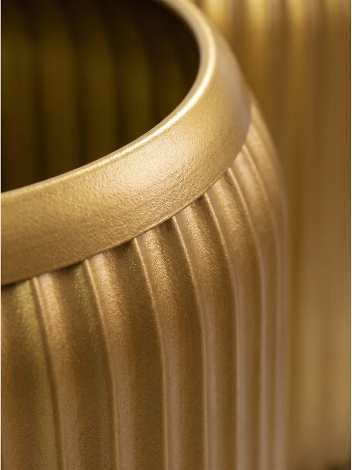 Nahaufnahme der vertikalen Rillenstruktur des goldenen Metalltisches zeigt das lackierte Finish und die präzise Verarbeitung des Zylinders_