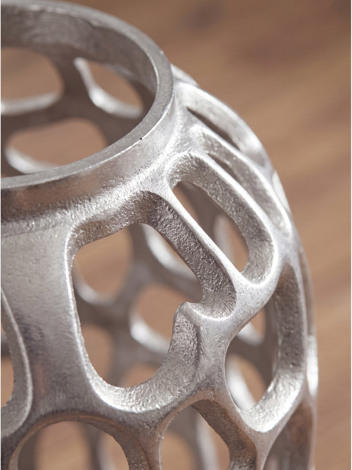 Nahaufnahme der handgefertigten Aluminium-Oberfläche der silbernen Dekovase, die die unregelmäßige zellulare Netzstruktur und den metallischen Glanz zeigt_