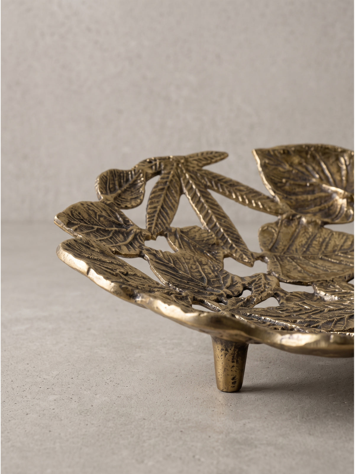 Ovale Schale aus goldenem Aluminium für die Präsentation von kleinen Deko-Objekten auf dem Couchtisch im klassisch eleganten Wohnzimmer.