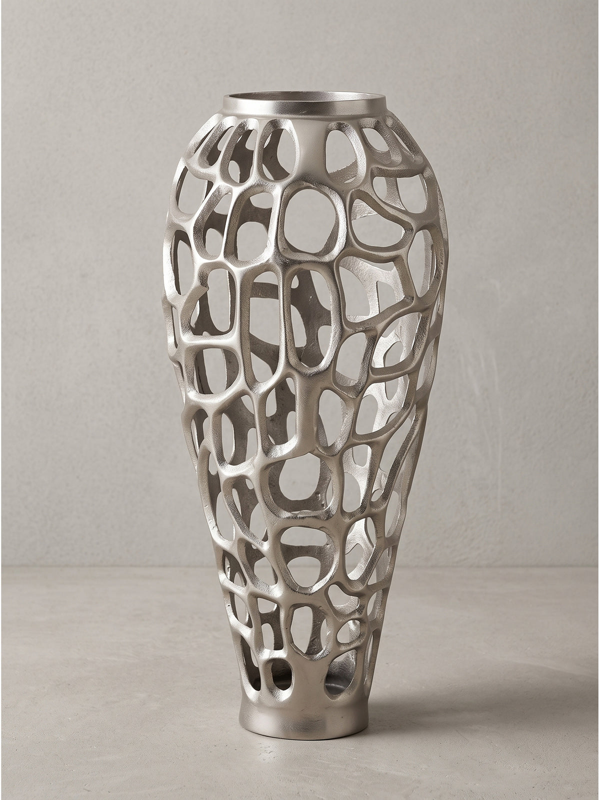 Seitenansicht der modernen Metallvase, die den eleganten Verlauf vom schmalen Fuß zur breiten Mitte bis zur runden Öffnung oben zeigt_