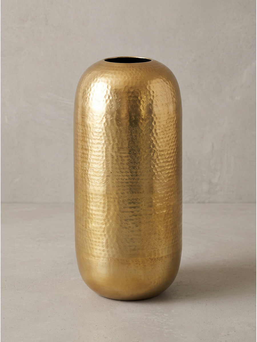 Moderne Bodenvase aus goldfarbenem Metall mit organisch gerundeter Silhouette präsentiert in einer leicht schrägen Ansicht_