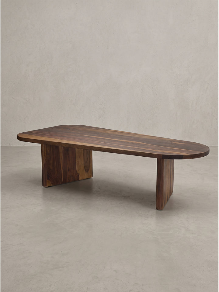Handgefertigter Couchtisch Sheesham Massivholz oval 120x60x32 cm mit zwei flachen Plattenfüßen freigestellt auf weißem Hintergrund_