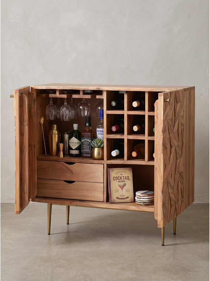 Leicht seitliche Perspektive auf die Design Hausbar mit markantem Holzrelief und filigranen Metallbeinen in Gold_