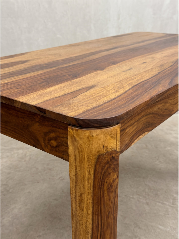 Alternative Winkelaufnahme des eleganten Massivholztisches zeigt das zeitlose Möbeldesign mit warmer rötlich-brauner Farbgebung_