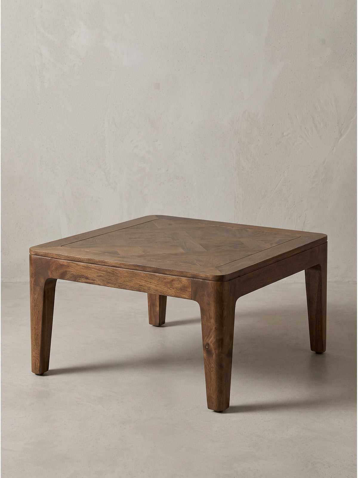 Freigestellter Couchtisch 60x60x32 cm aus handverarbeitetem Mango-Massivholz im tiefen Walnuss-Farbton schräg von vorn fotografiert.